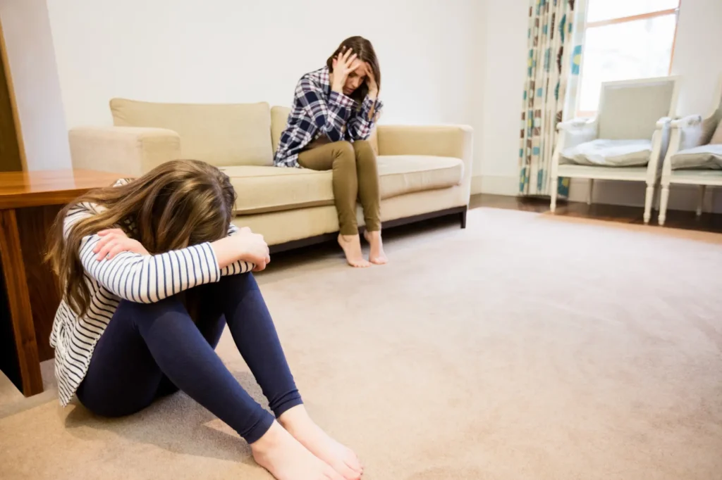 Una madre a sentada a una distancia de su hija tomándose un tiempo antes de hablar como se recomienda en la crianza consciente